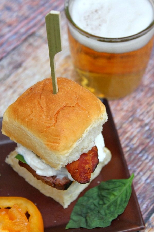 looking down on a filet mignon caprese slider with a glass of beer