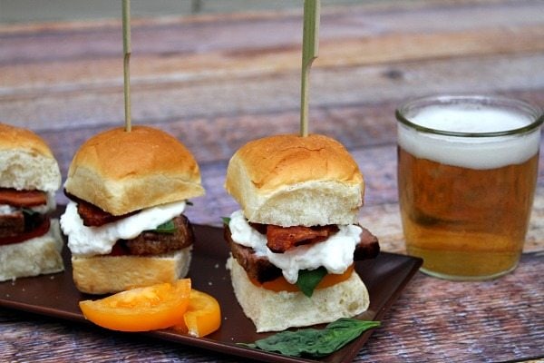 tray of filet mignon caprese sliders each skewered with a long sandwich pick. Beer on the side