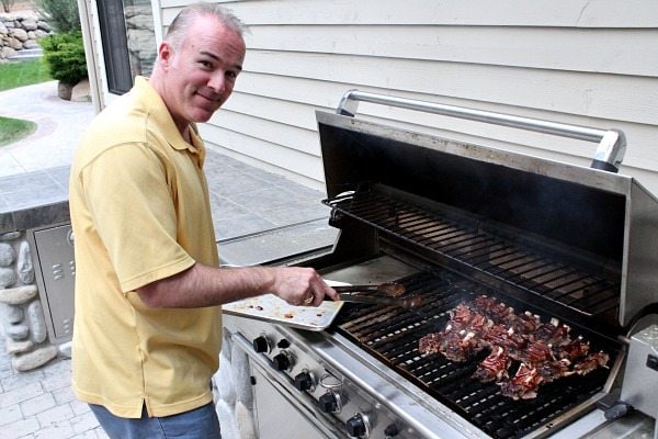 man cooking ribs on the grill