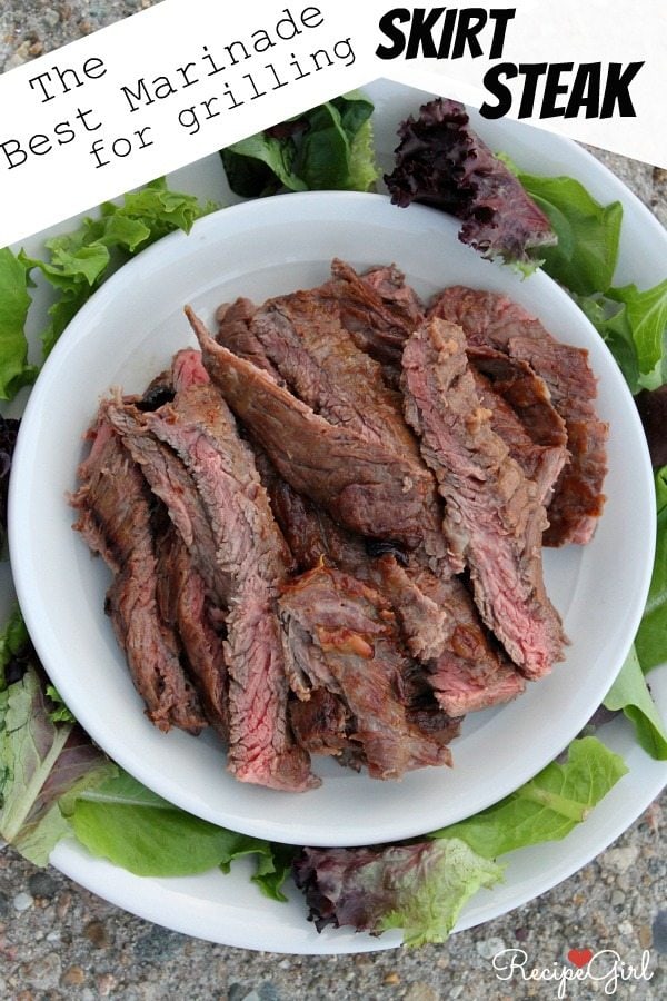 Grilled Skirt Steak sliced and displayed on a white platter surrounded by lettuce leaves