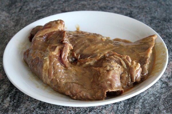 Marinated Skirt Steak sitting on a white platter