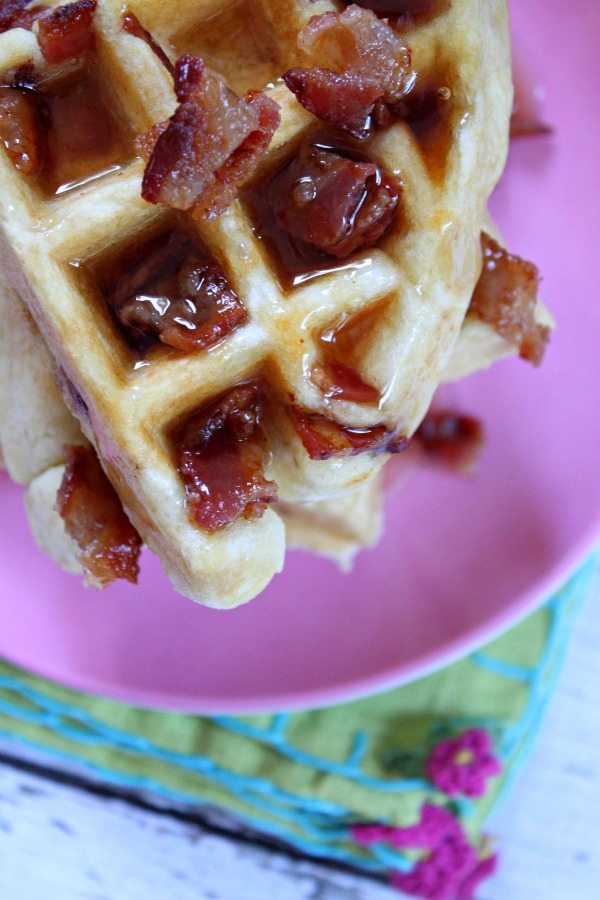 Looking down on a maple bacon waffle on a pink plate