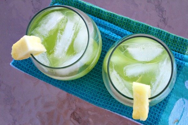 Overhead shot of two pearl harbor cocktails garnished with pineapple sitting on a blue towel