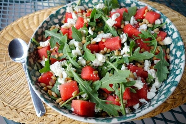 blue and white bowl filled with watermelon, feta and arugula salad