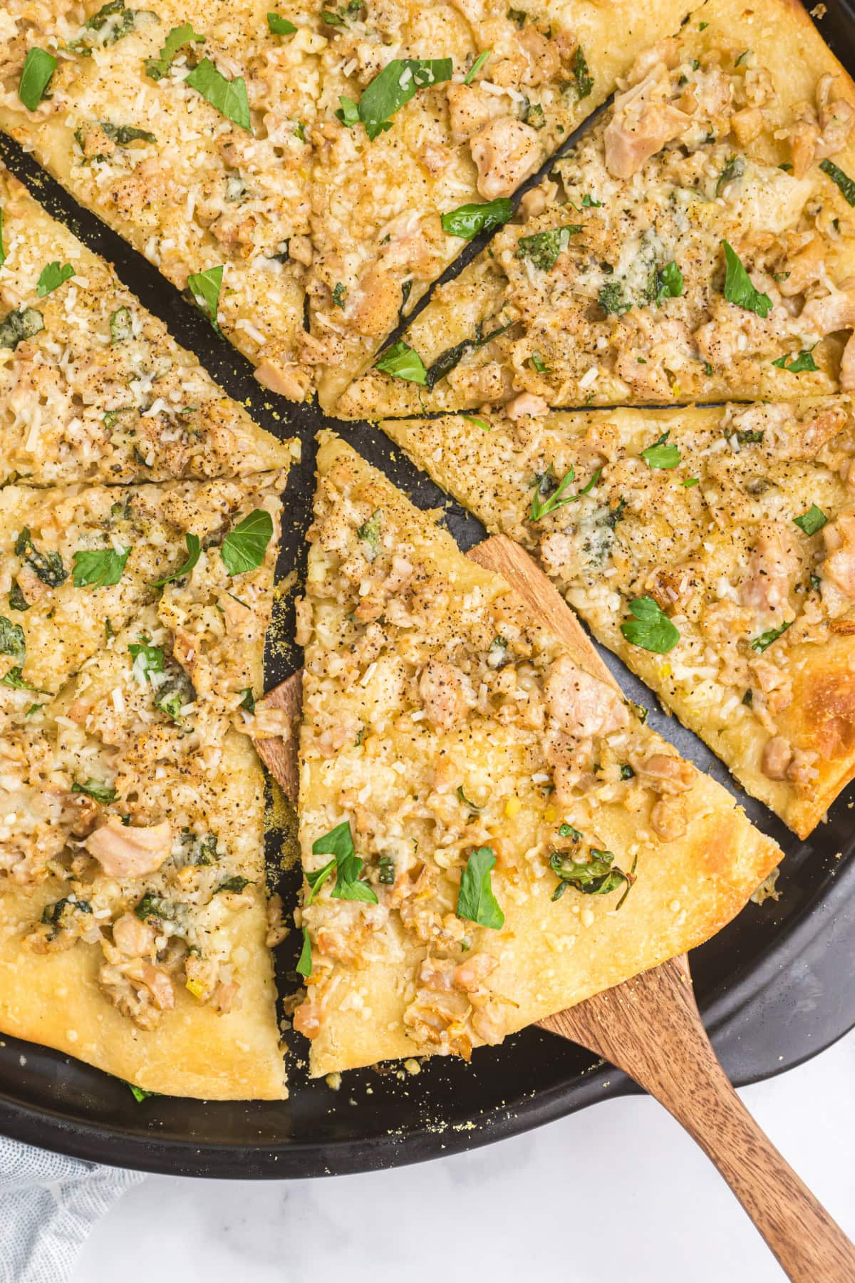 white clam pizza sliced into pieces