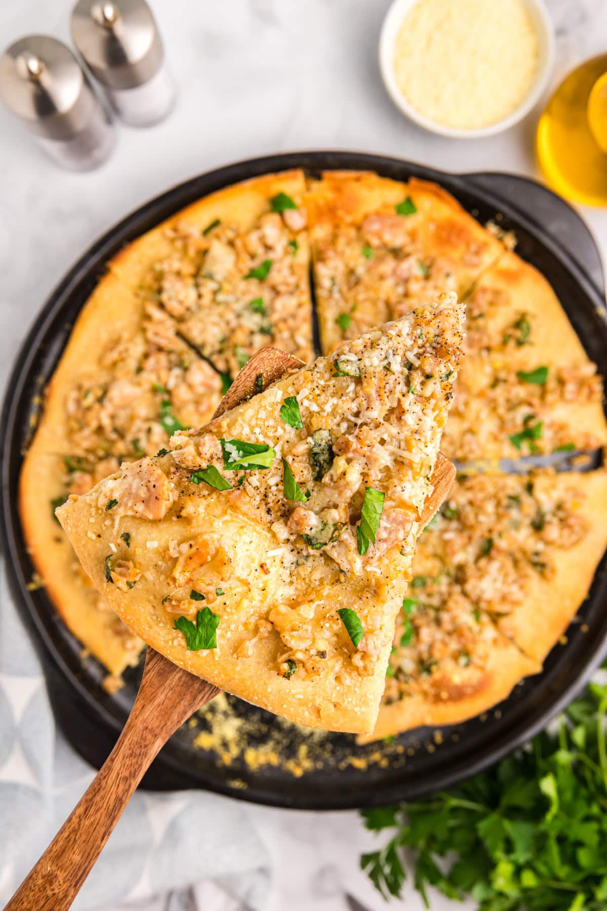 spatula holding up slice of white clam pizza