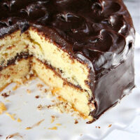 yellow cake on cake stand with big slice taken out of it