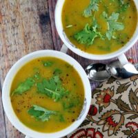 overhead shot of two bowls of butternut squash and kale soup