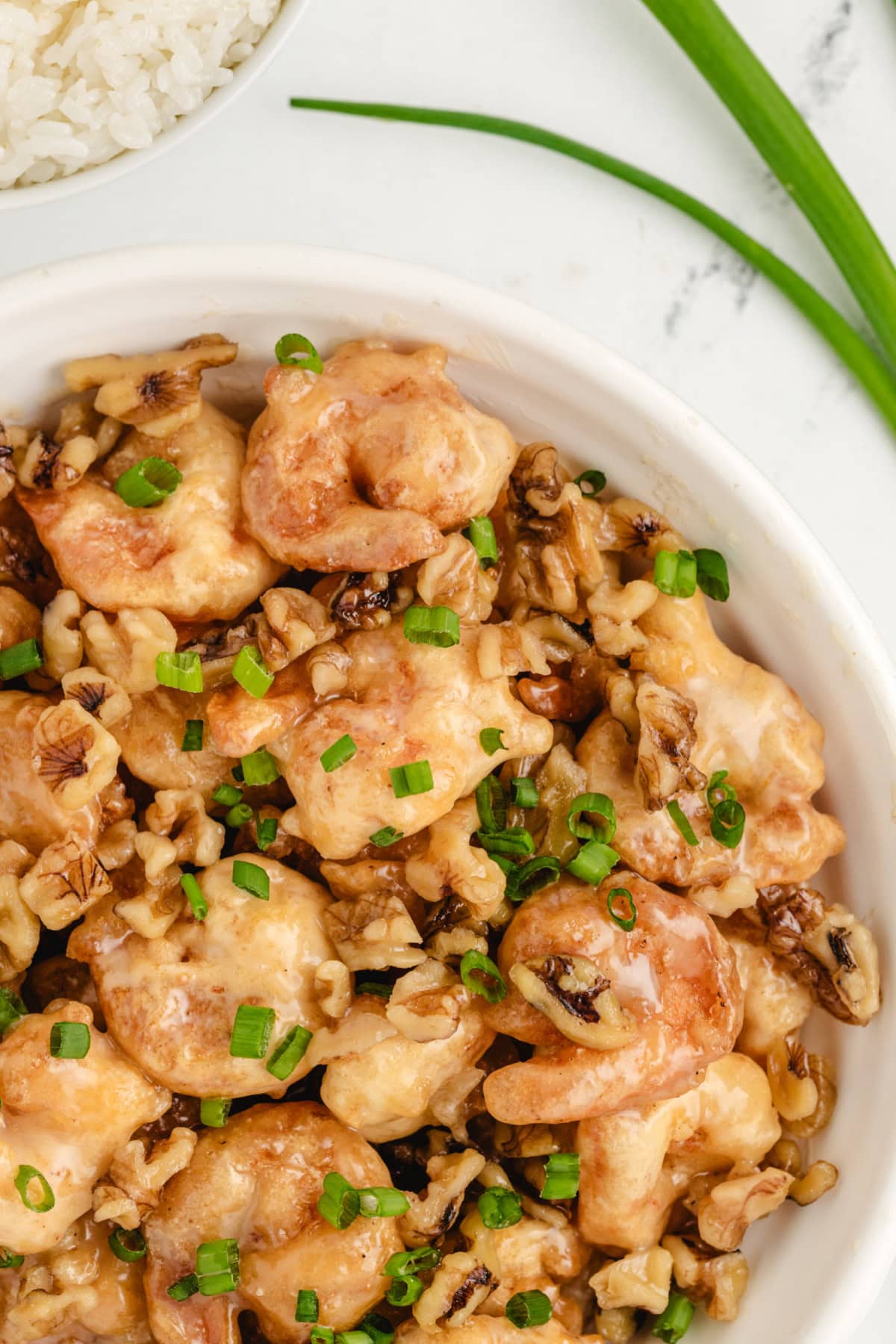Honey Walnut Shrimp recipe from RecipeGirl.com : This easy to make Asian meal is crispy shrimp in a sweet, creamy sauce with candied walnuts. It's a popular Chinese takeout recipe. honey walnut shrimp in white bowl