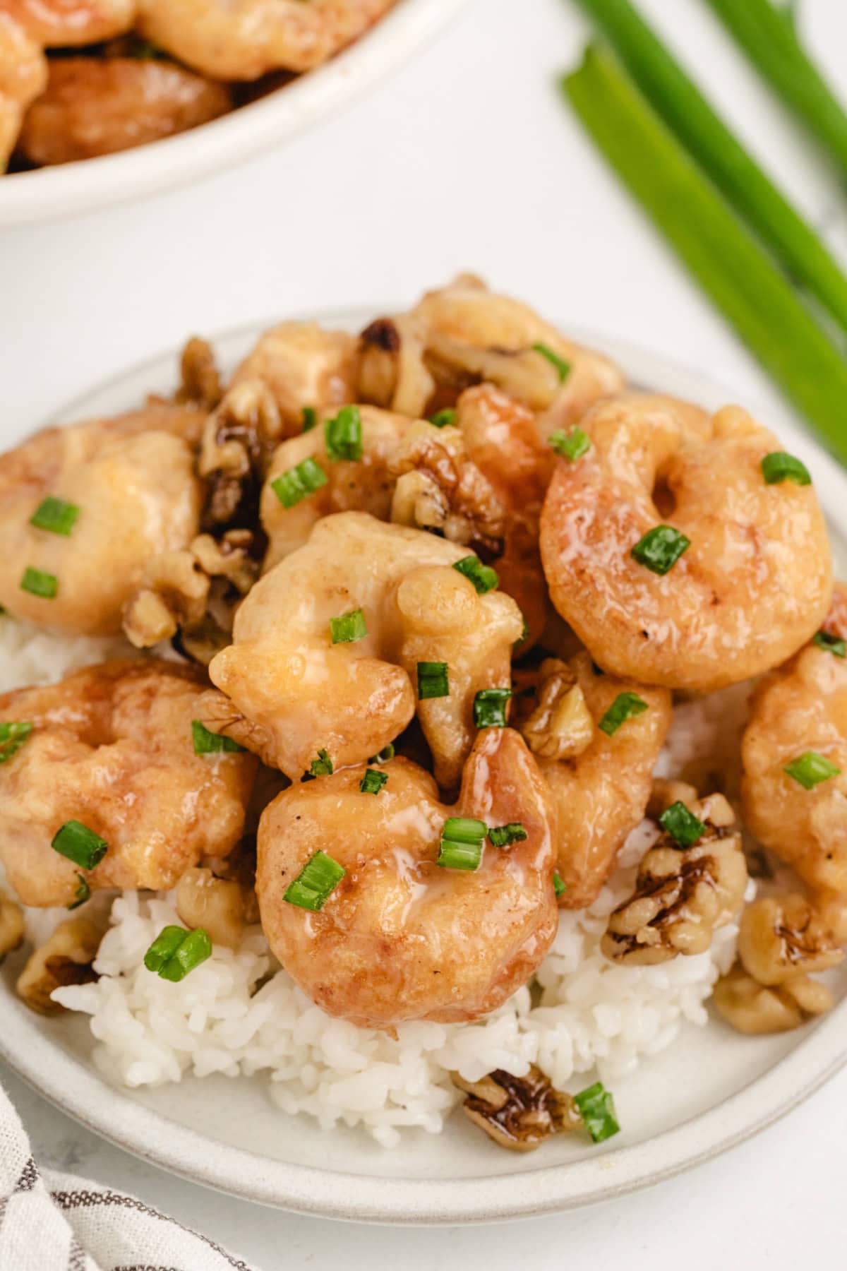 Honey Walnut Shrimp recipe from RecipeGirl.com : This easy to make Asian meal is crispy shrimp in a sweet, creamy sauce with candied walnuts. It's a popular Chinese takeout recipe. serving of honey walnut shrimp over rice on plate
