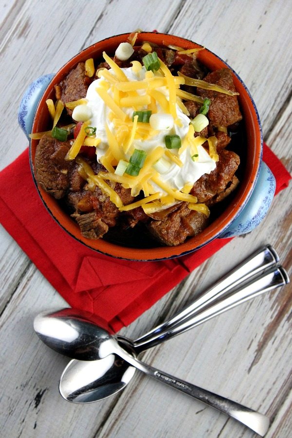 Overhead shot of Steak and Beer Chili in bowl with spoons