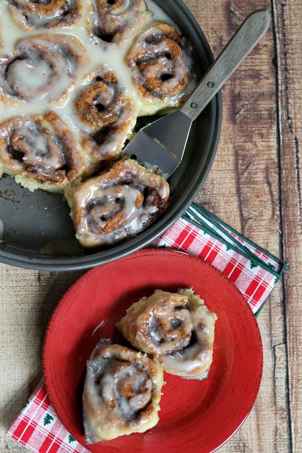 No Yeast Eggnog Cinnamon Rolls in a pan and served on a red plate