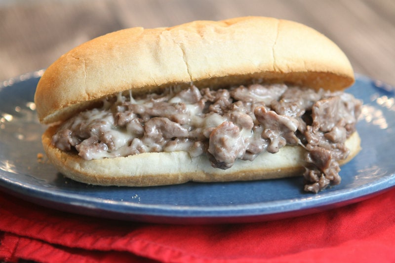 Philly Cheese Steak Sandwiches recipe from RecipeGirl.com #philly #cheese #steak #cheesesteak #sandwiches #recipe #RecipeGirl Philly Cheese Steak Sandwiches on a blue plate