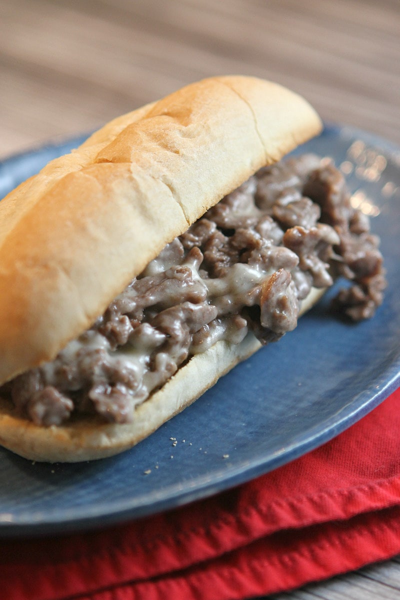 Philly Cheese Steak Sandwiches recipe from RecipeGirl.com #philly #cheese #steak #cheesesteak #sandwiches #recipe #RecipeGirl Philly Cheese Steak Sandwiches close up on a blue plate