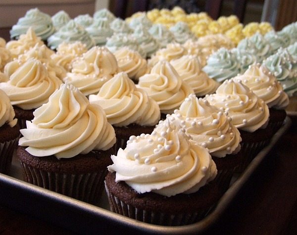 wedding cupcakes in assorted colors on a baking sheet