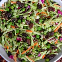 overhead shot of a bowl of broccoli slaw set on top of a burgundy striped cloth napkin