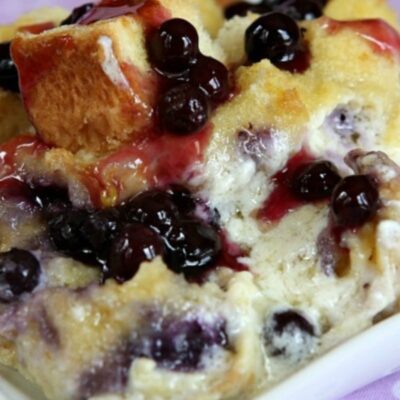 overnight blueberry french toast on a white plate set on a purple cloth napkin