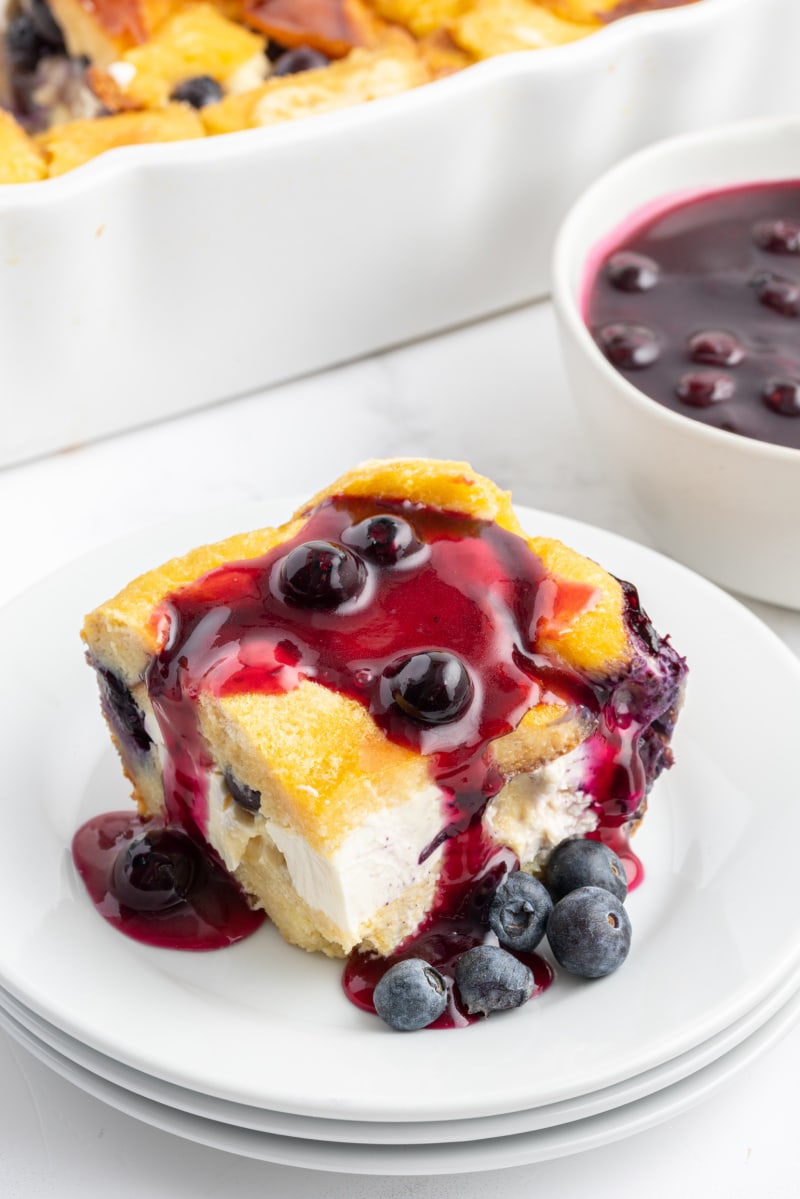 slice of overnight blueberry french toast on plate with blueberry sauce