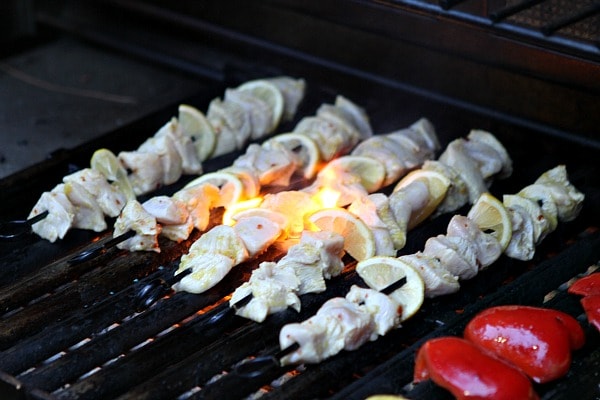 rosemary lemon chicken skewers on the grill with fire