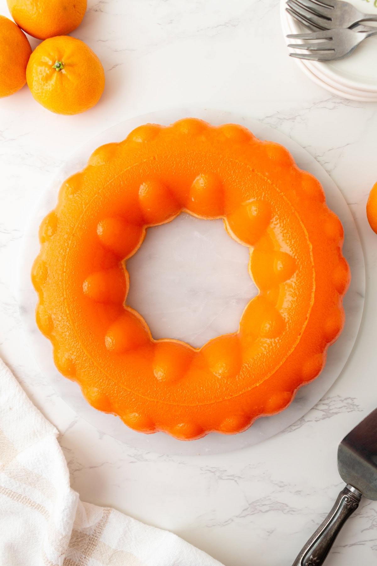 Cool, creamy, and perfectly nostalgic — this Orange Sherbet Jello Salad is made with orange Jell-O, sherbet, and mandarin oranges. The perfect citrusy dessert for holidays, brunches, and family gatherings! overhead shot of molded orange sherbet jello salad ring