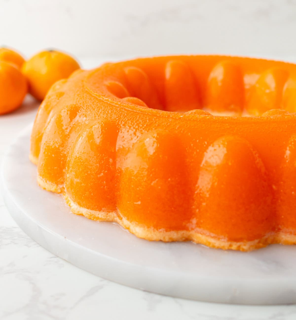 Cool, creamy, and perfectly nostalgic — this Orange Sherbet Jello Salad is made with orange Jell-O, sherbet, and mandarin oranges. The perfect citrusy dessert for holidays, brunches, and family gatherings! orange sherbet jello salad on platter