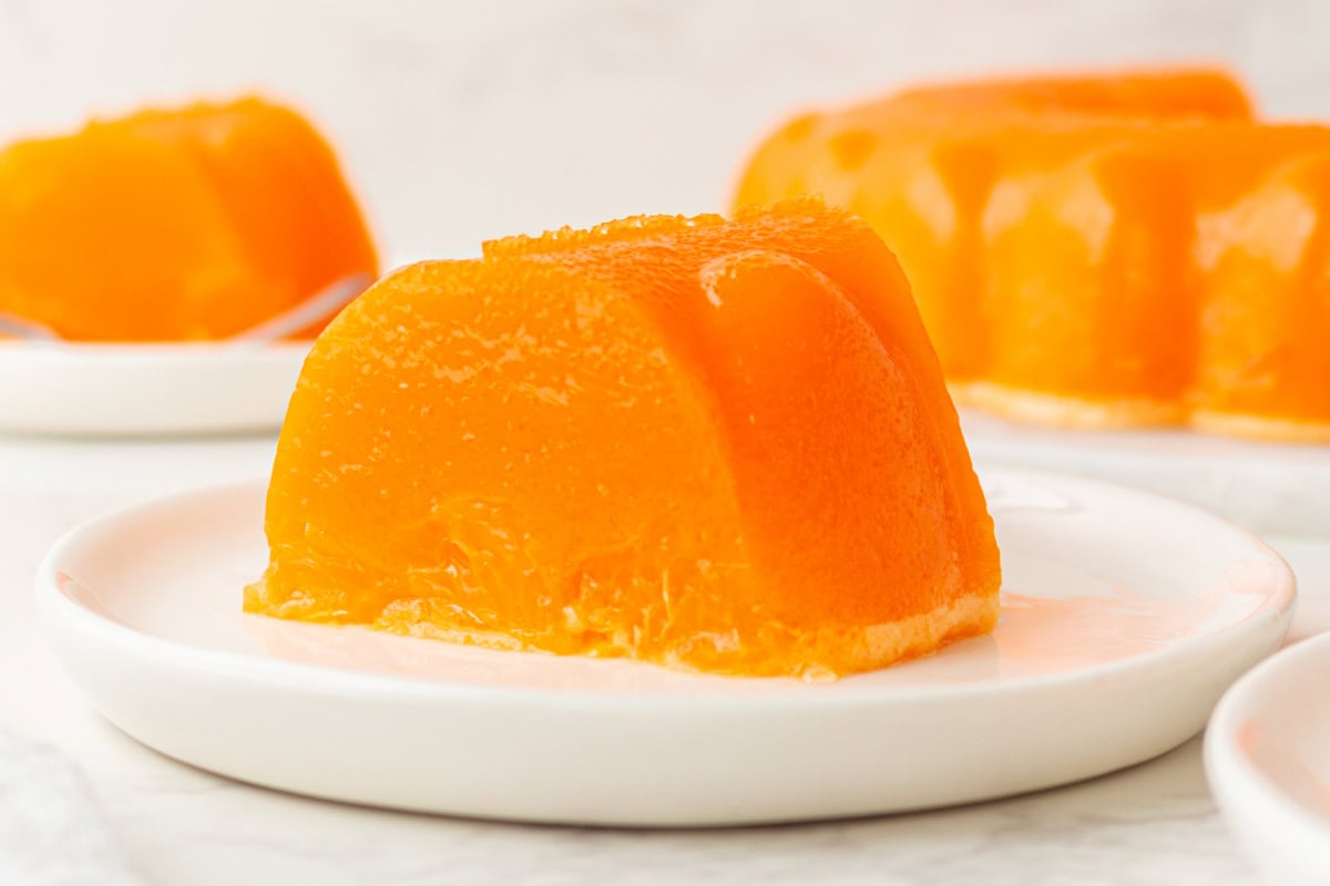 Cool, creamy, and perfectly nostalgic — this Orange Sherbet Jello Salad is made with orange Jell-O, sherbet, and mandarin oranges. The perfect citrusy dessert for holidays, brunches, and family gatherings! plate of orange sherbet jello salad