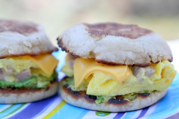 Two Camping Breakfast Sandwiches sitting side by side on a striped tablecloth