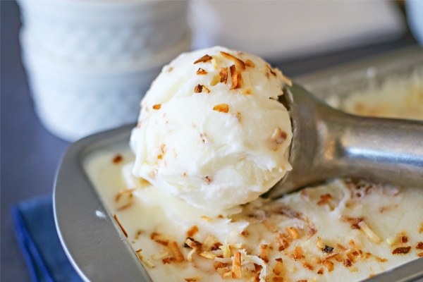 Coconut Frozen Yogurt being scooped out of a tin with an ice cream scoop