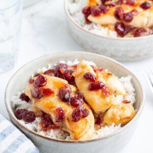 apricot cranberry chicken in bowls over rice