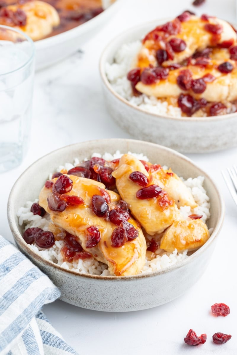 apricot cranberry chicken in bowls over rice