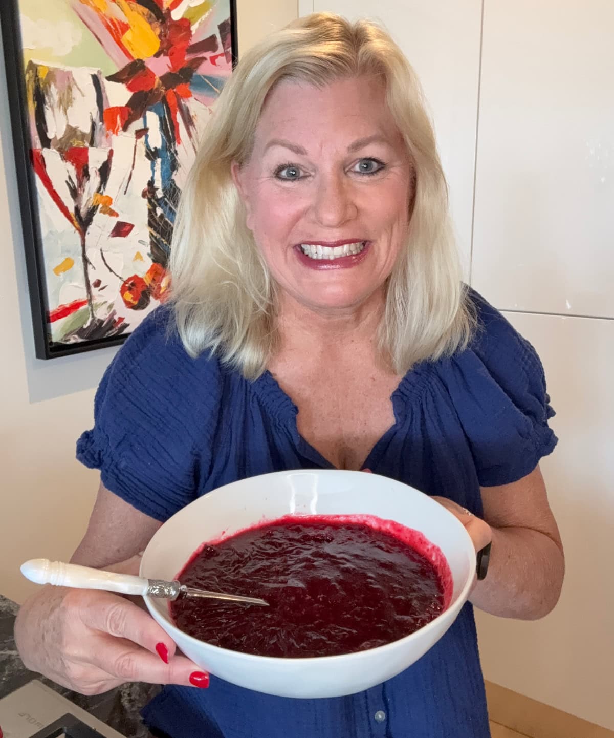 Sweet, tart, and full of flavor — this Sherry Triple Berry Cranberry Sauce combines cranberries, blueberries, and raspberries with a splash of sherry for the ultimate holiday side. recipegirl with bowl of sherry triple berry cranberry sauce