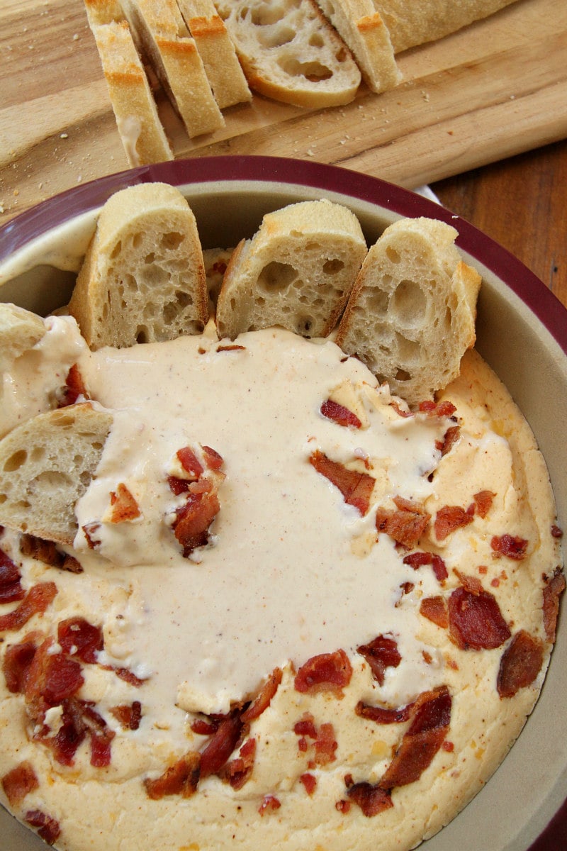 Baguette slices and Beer and Bacon Dip in a bowl