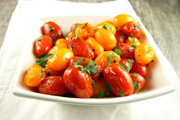 sauteed tomatoes with thyme in a white bowl garnished with fresh parsley