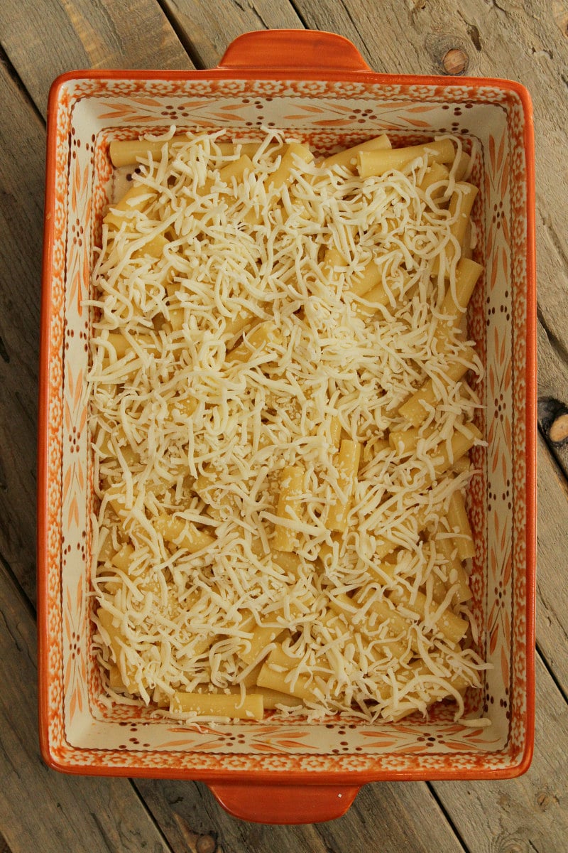 overhead shot of making pastitsio in process looking at noodles and cheese in the casserole dish