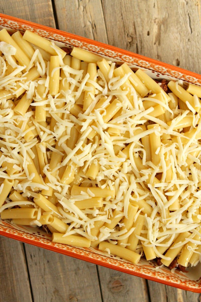 overhead shot of making pastitsio in a casserole dish in process - noodles and cheese