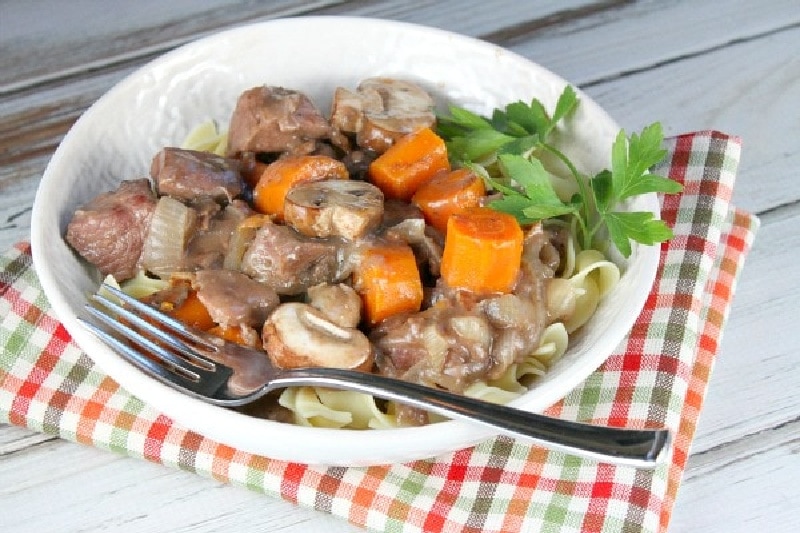 beef burgundy served over noodles in a bowl