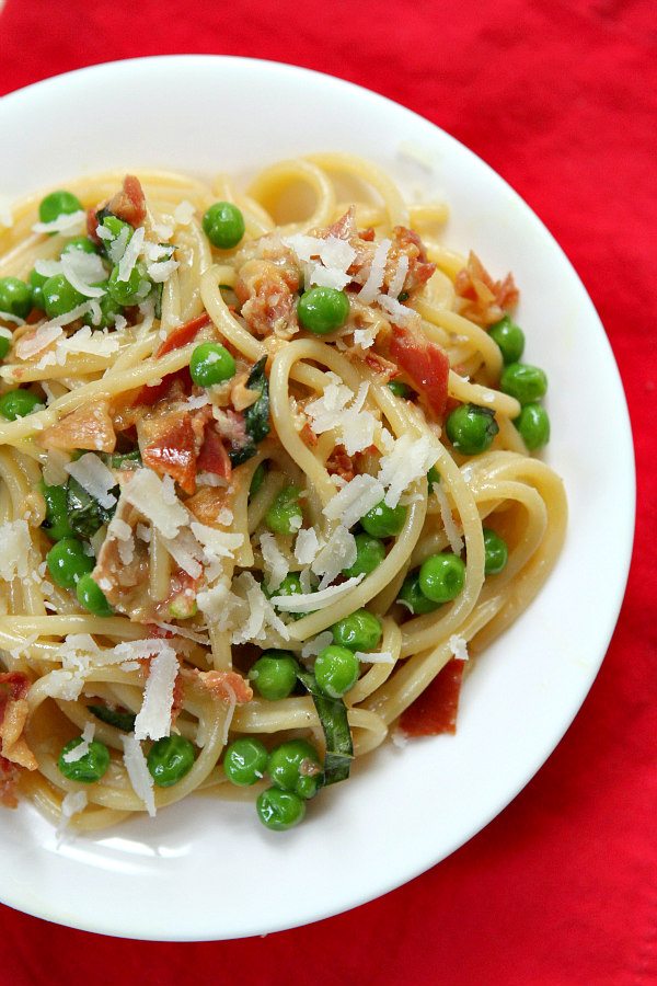 overhead shot of spaghetti carbonara on a white plate set on a red napkin