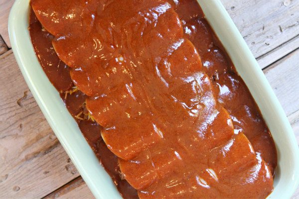 Beef and Cheese Enchiladas Prep with sauce over in pan