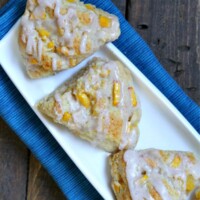 overhead shot of fresh peach scones on a white platter set on a blue napkin