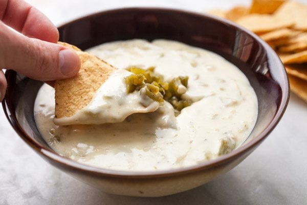dipping chip into Hatch Chile Queso
