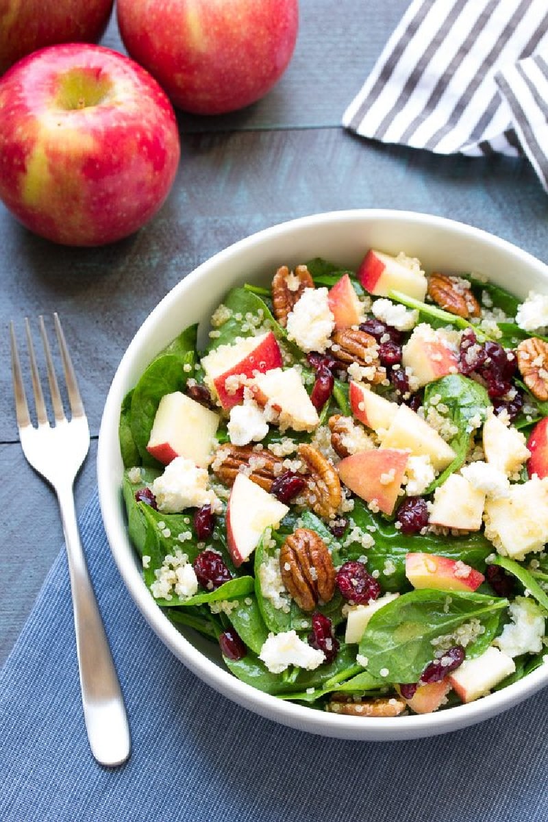 spinach and quinoa salad in a white bowl