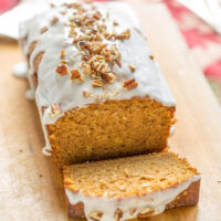 pumpkin loaf cake on cutting board with slice taken out of it