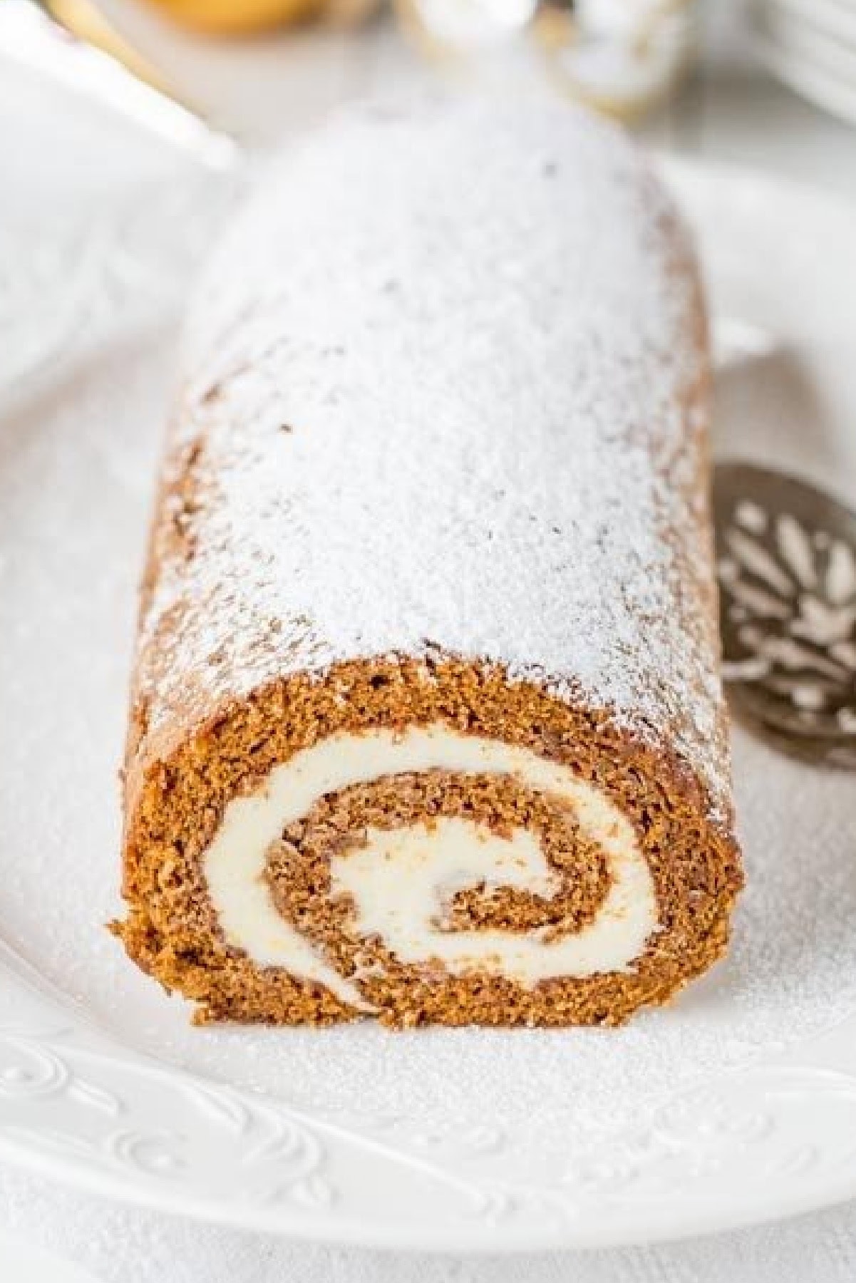 Gingerbread Roll 🎄✨ A festive holiday cake with soft gingerbread sponge, warm spices, and creamy lemon cream cheese filling. Perfect for Christmas dessert tables! close up gingerbread roll 1200