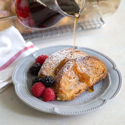 pouring syrup onto eggnog french toast casserole