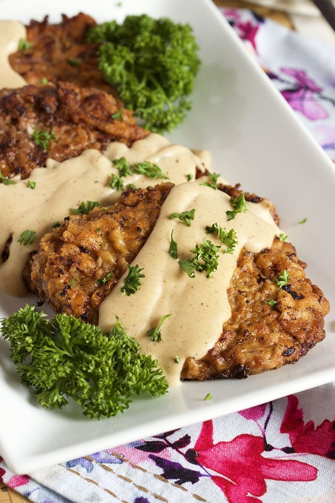 chicken fried steak topped with gravy and fresh parsley