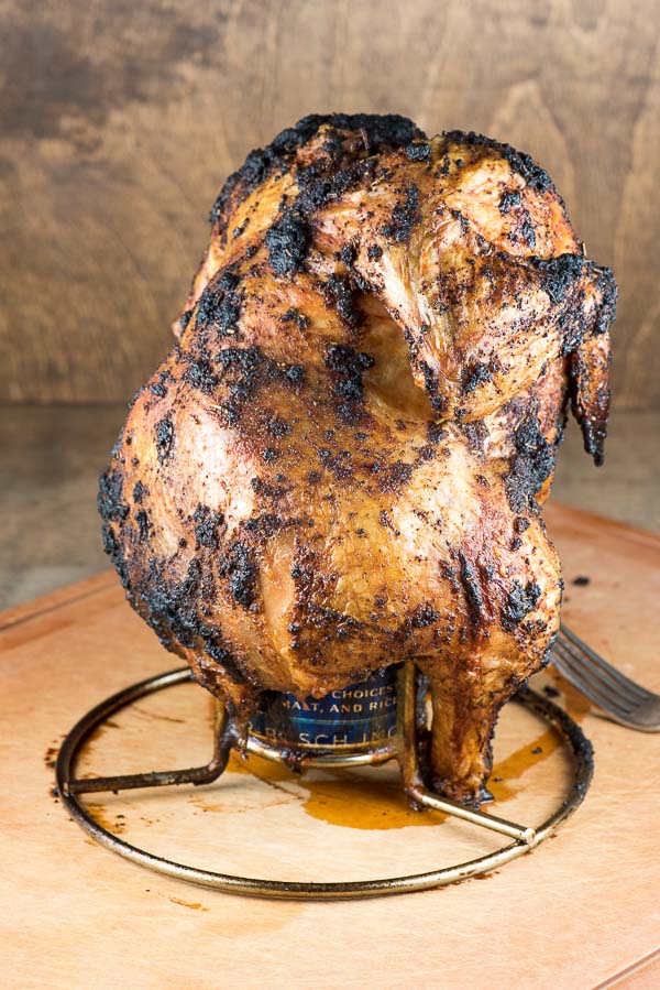 Grilled Beer Can Chicken on a rack sitting on a cutting board