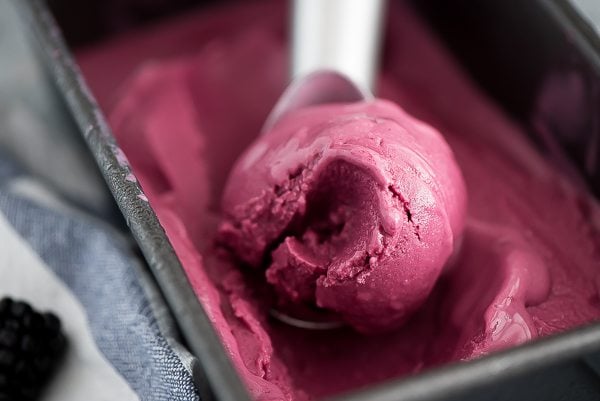 Blackberry Frozen Yogurt being scooped out of a metal container