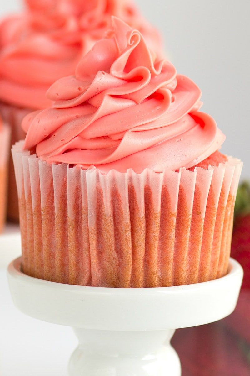 pink strawberry cupcake on a white cupcake stand