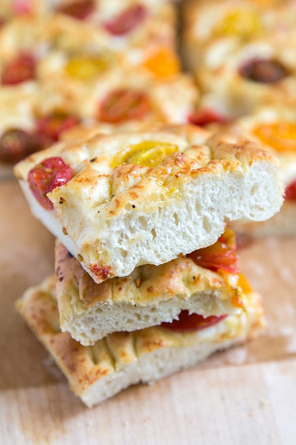 stacked Tomato Focaccia Bread slices with more focaccia in the background