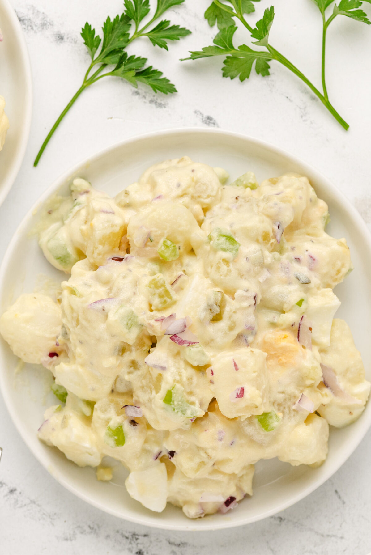 The perfect potato salad for every barbecue! American Potato Salad recipe from RecipeGirl.com serving of american potato salad on plate